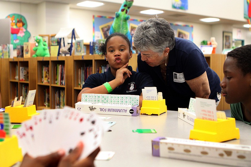 Booker Middle School's bridge club advisor, Jane Huerta, helps Jamiliah Walker with her next move during the bridge club's final meeting Monday, May 23 inside Gocico Elementary School's Media Center.