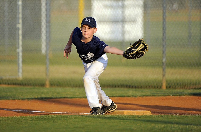 Nine-year-old Carter Chapin catches the ball cleanly to record an out at first base.