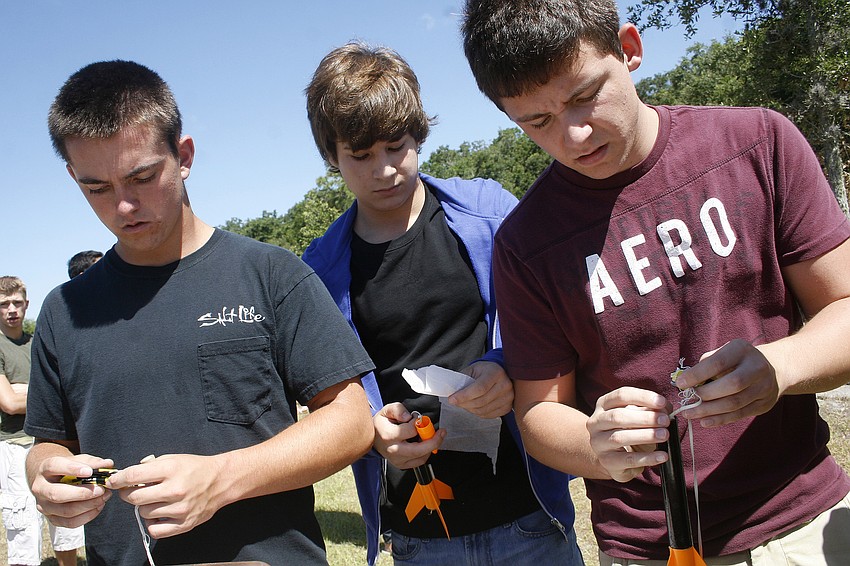 Forrest Wilson, Justin Guida and David Lakin install the parachutes inside their rockets.
