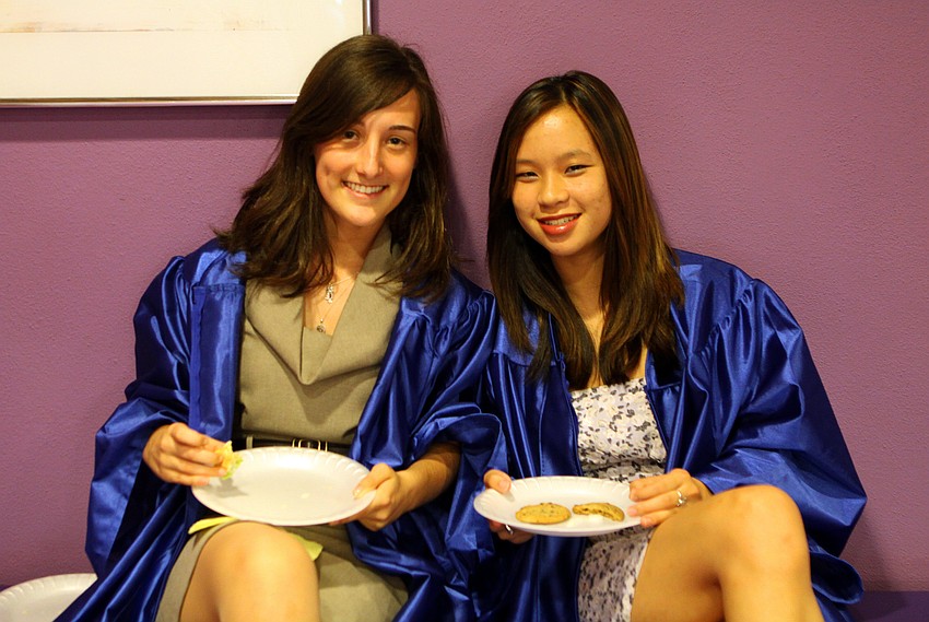 Marine Robbins and Marlia Sylvestre enjoy some food prior to having to get full into their caps and gowns for graduation Sunday, June 5 at Van Wezel.