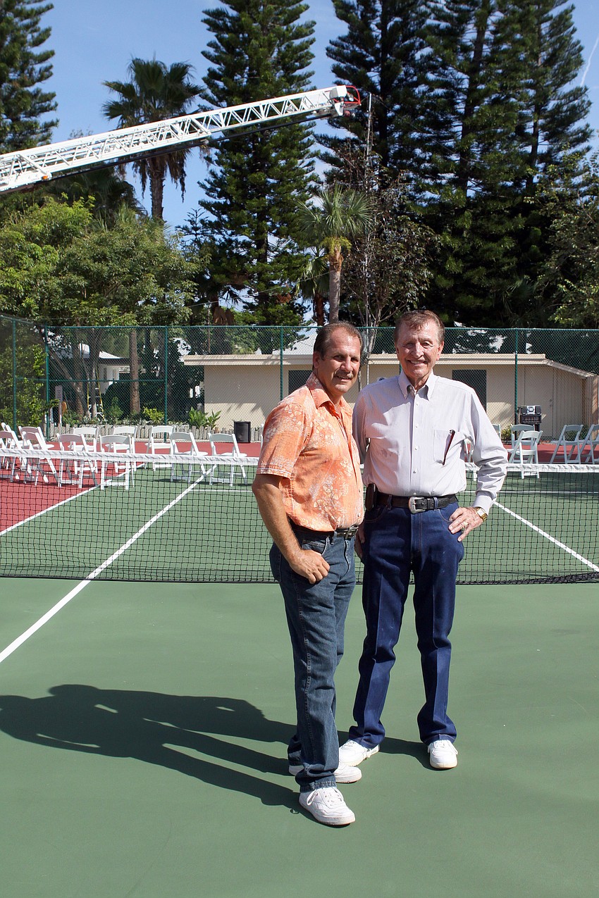 Mark Meador and D.M. Williams pose together on the tennis court with the fire truck and cotton plant in the background Friday, July 15 at Casa del Mar.