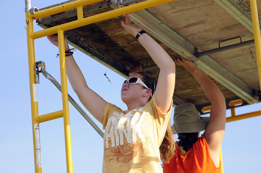 Ashley Hall and Brianne Cozzette work together to put up the staff scaffolding.