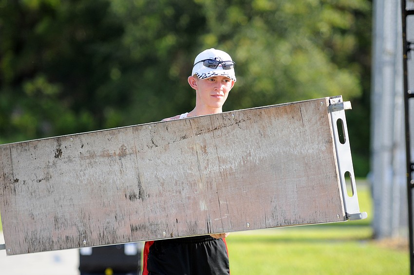 Zack Funk carries over a piece of the staff scaffolding.