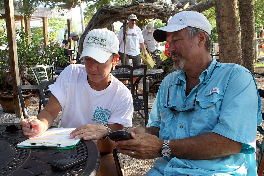Alison Albee and Tim Thurman look at their assigned area and their handheld GPS to figure out where they would be heading out Saturday, August 13 during the 4th Annual Sarasota Bay Great Scallop Search.
