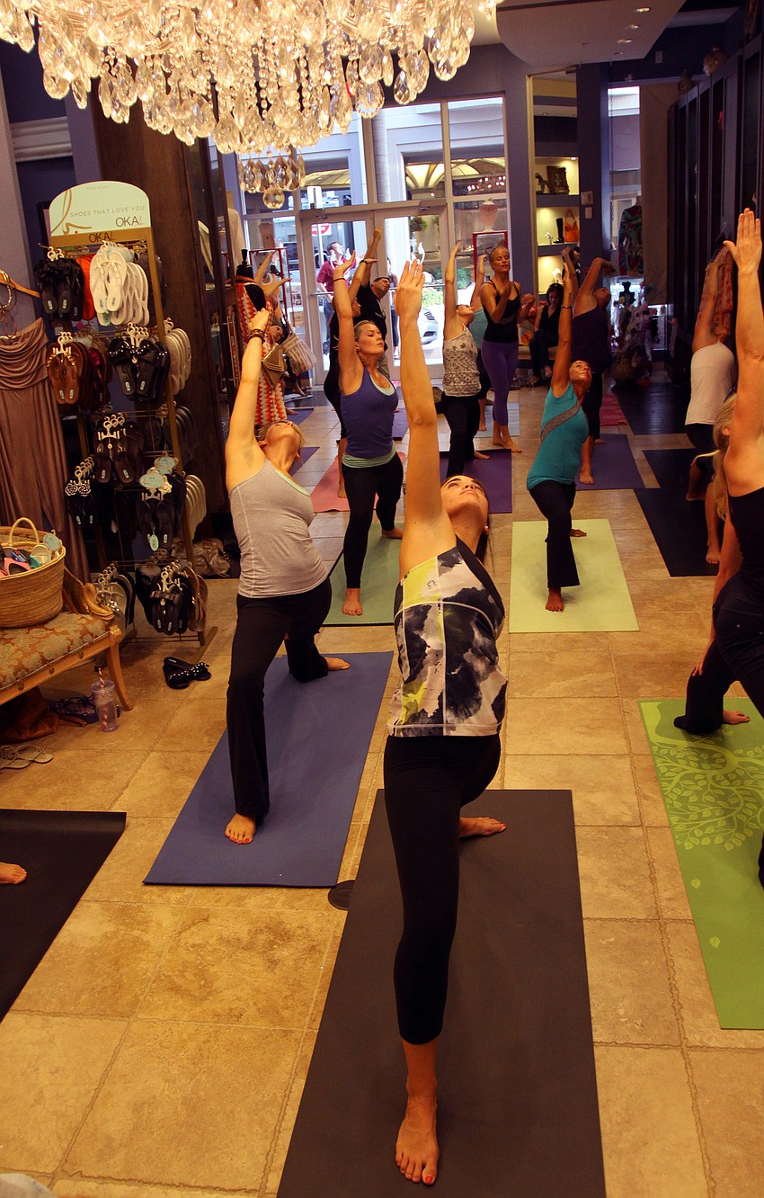 The class moves into triangle pose Friday, Aug. 26 during Vinyasa & Vino at T. Georgianos.