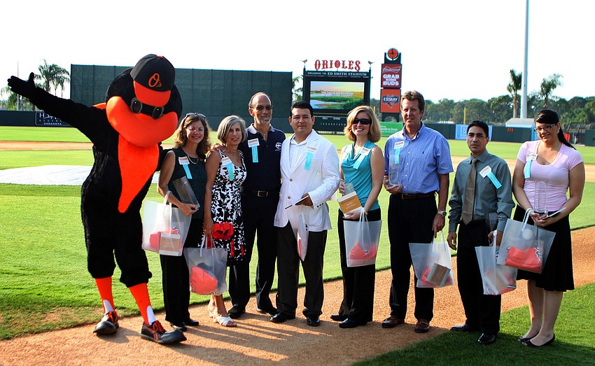 The winners of the 2011 National Tourism Week Awards pose with The Bird on the field Thursday, May 12, at Ed Smith Stadium.