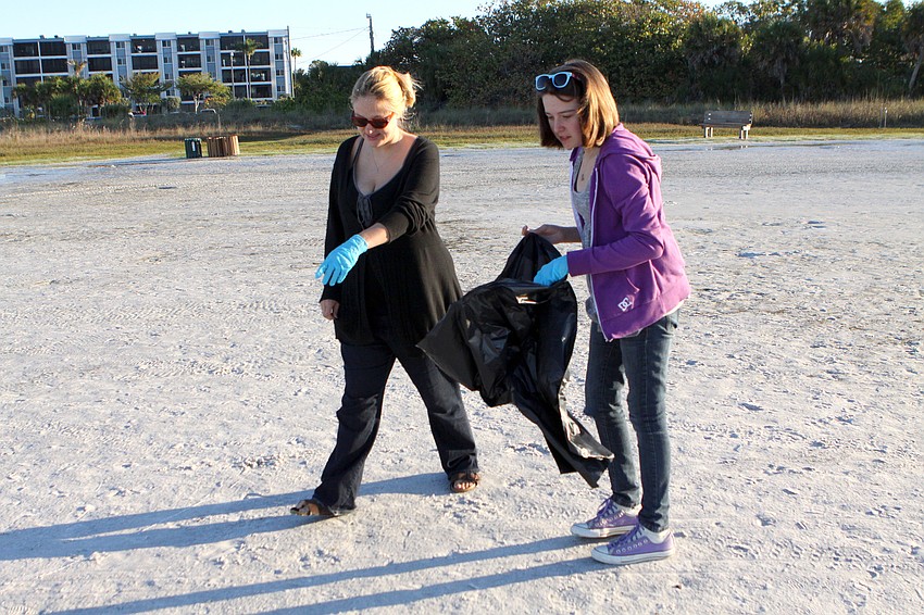 Courtney Folian points out a piece of trash to her daughter, Veronica, 12, on Saturday, April 2, on Siesta Key Beach during the 2011 Great American Cleanup, part of Keep Sarasota County Beautiful.