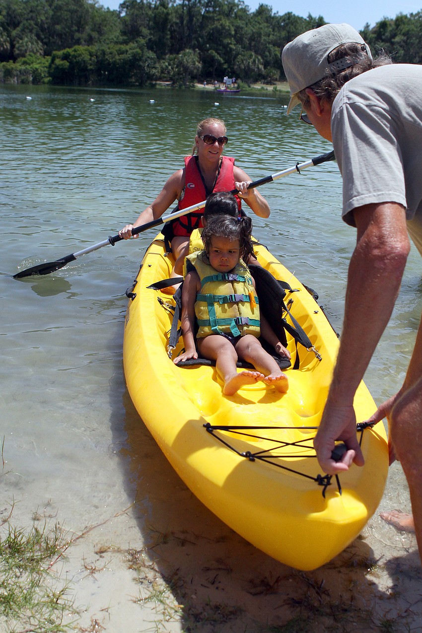 Larry Best pushes Tammy LaBar off the shore in a kayak with her kids Jacob, 3, and Jasmine, 4, during the Earth Day Celebration on Sunday, April 17 out at Oscar Scherer State Park in Osprey.