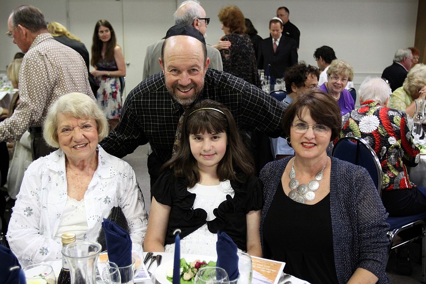Larry Diner wraps his arms around his mother-in-law, Ruth Robinson, his daughter, Emma, and his wife, Laurie, prior to Seder dinner on Monday, April 18 at Temple Emanu-El. Passover began Monday at sundown.
