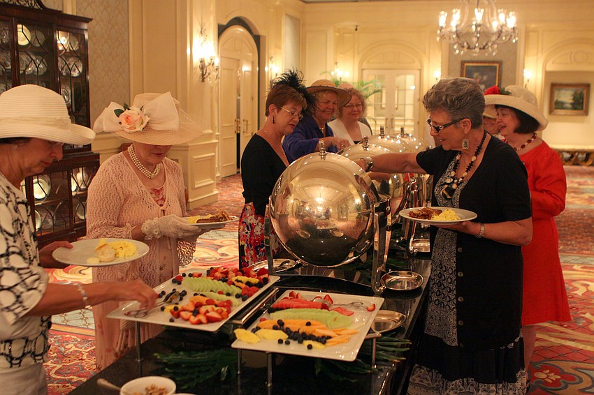 People fill their plates with British food while participating in the royal wedding party Friday, April 29 at the Ritz Carlton.