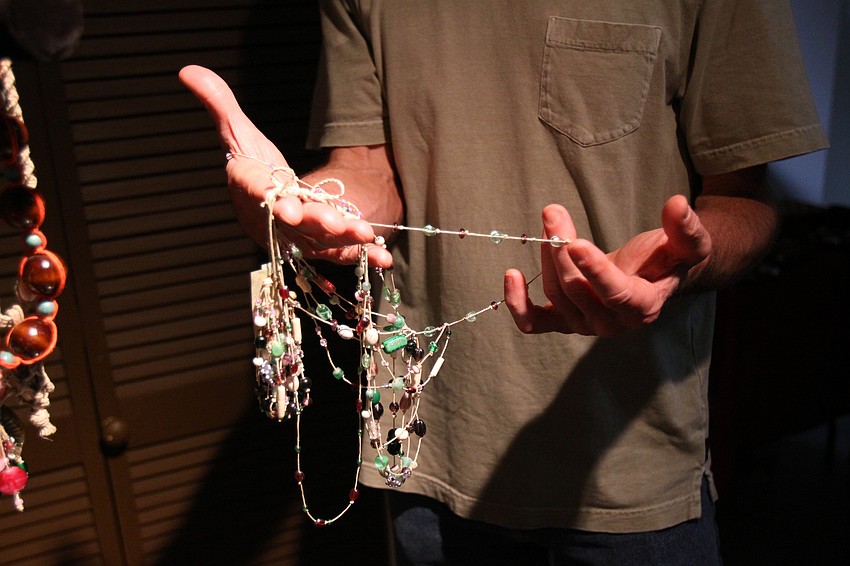 Stuart Zimmer looks at a necklace and bracelet set Friday, May 6 during the Wine, Cheese and Beads event at Five Points Collective.