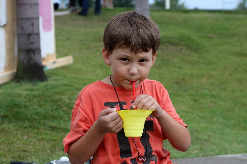 Benjamin Alexander Burden, 7, enjoys a grape and strawberry icy Saturday, May 14 during the Golden Era Tour event at Payne Park's skate park.