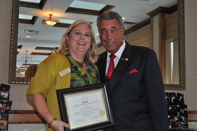 Jamie Aymerich, Sarasota Magazine accepts an award from St. Armands Circle Association President Andrew Vac.