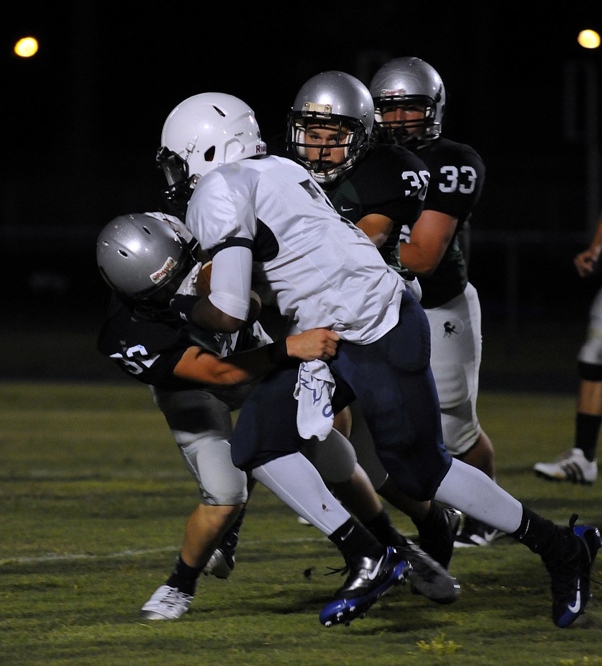 Several Lakewood defenders bring down North Port quarterback Denzel Daniel.