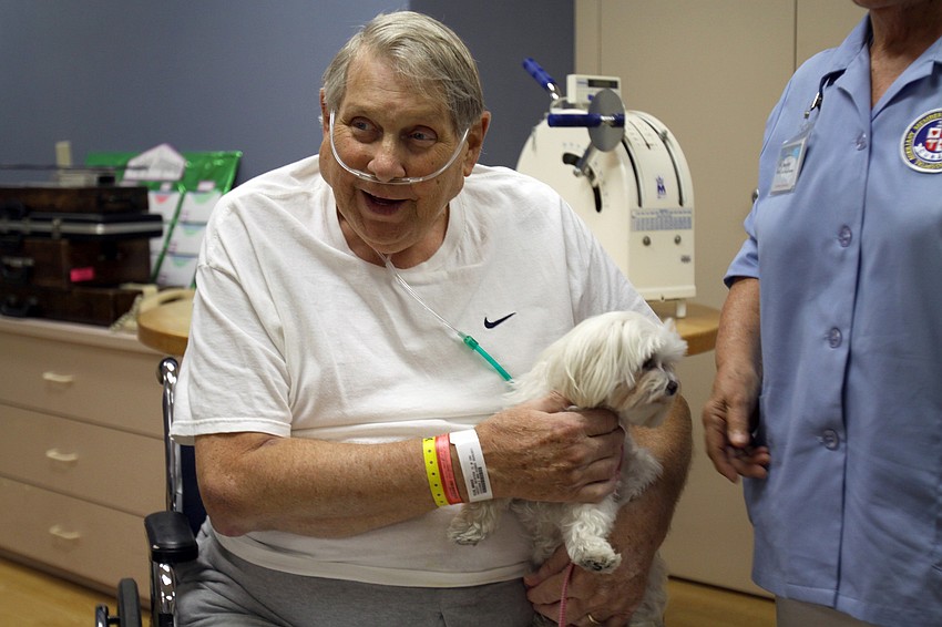 Bruce Ellis holds Alie while he talks to other people in the Comprehensive Rehabilitation Unit Thursday, May 12 at Sarasota Memorial Hospital.