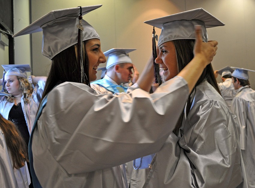 Nicolle Zampella helped Nicole Tira adjust her cap before the ceremony