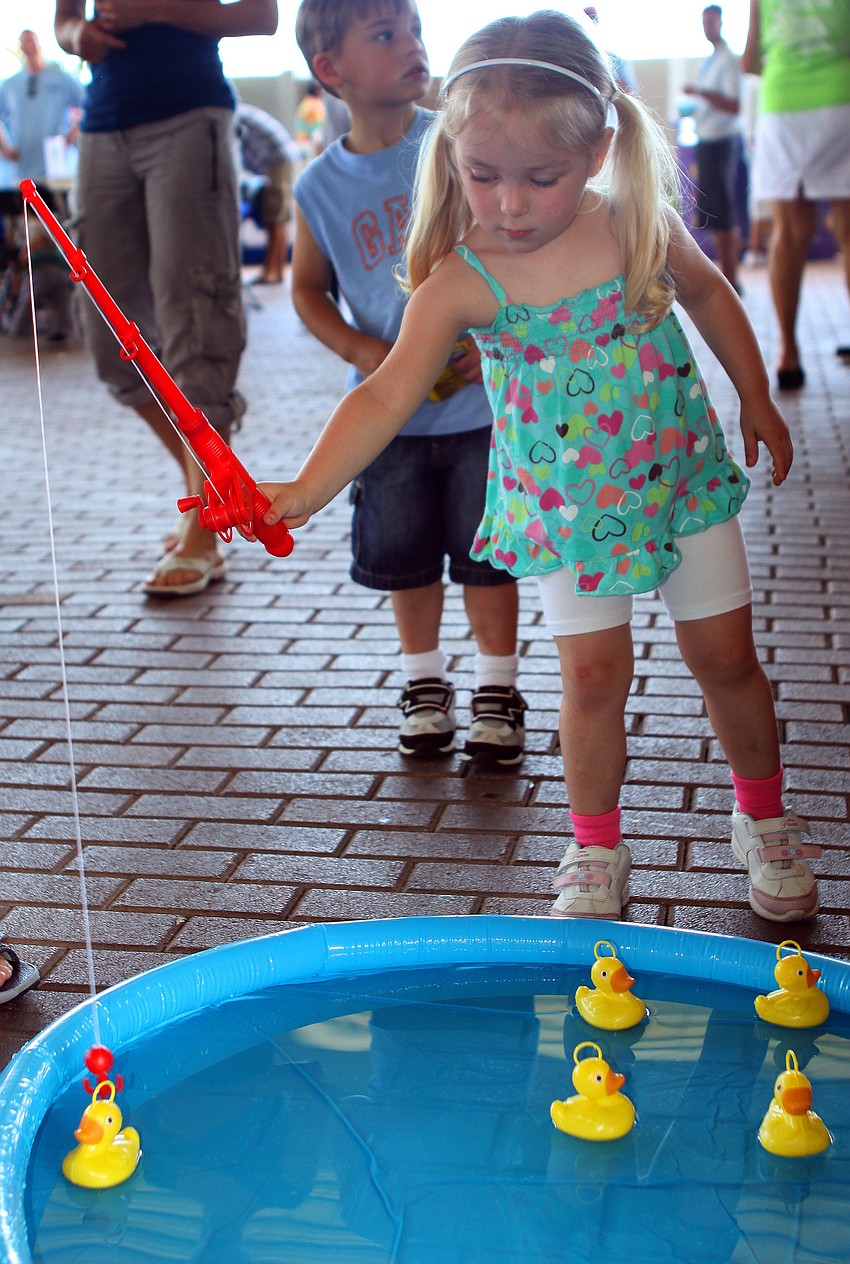 Addison Carlisle, 3, tries to fish a duck out of a blow-up swimming pool during the World Ocean Day Family Festival Sunday, June 5 at Mote Aquarium.