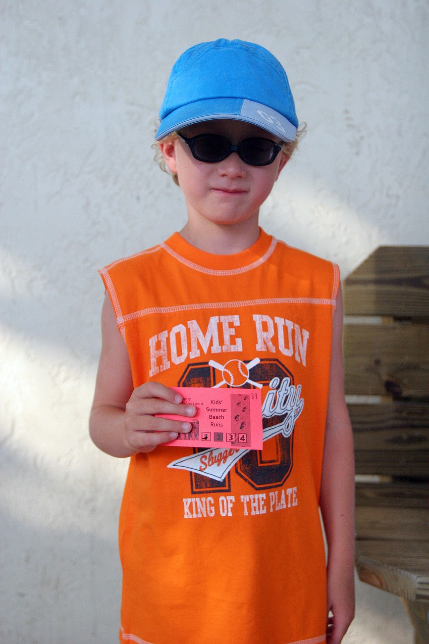 Tim Kuehn, 6, from Germany, shows off his Kids' Summer Beach Runs ticket prior to being in the 1-mile fun run Tuesday, June 14 on Siesta Key Beach. Once a participant completes four of the ten runs they receive a t-shirt.