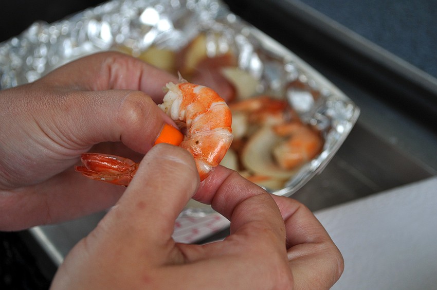 Kiersten Schmidt tears into some shrimp at the Sarasota Farmers Market first ever Shrimp and Lobster Festival.