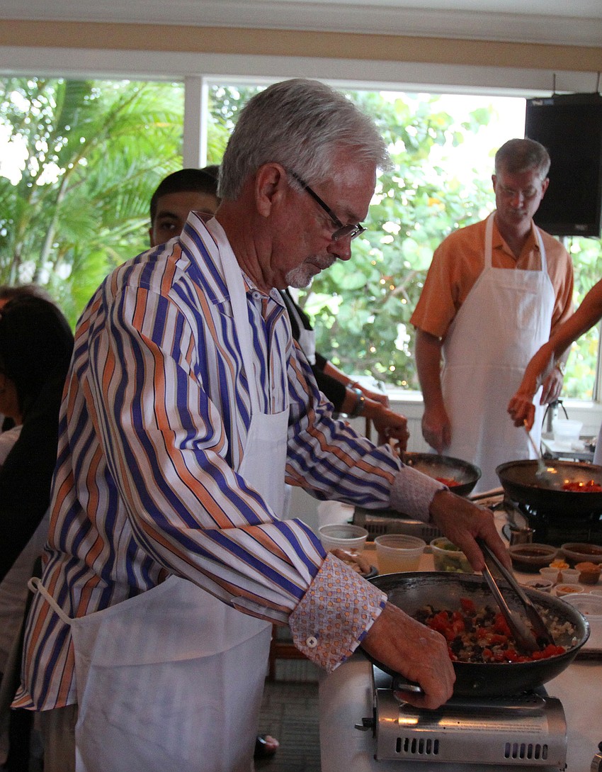Mayor Jim Brown works on cooking the first dish in the skillet Friday, July 22 during the Interactive Mexico dinner at Pattigeorgeâ€™s.