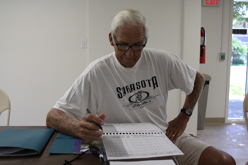 Bob Clousson reads through his manual Saturday, July 30 inside the Turtle Beach Community Center where the seagrass meeting was held.