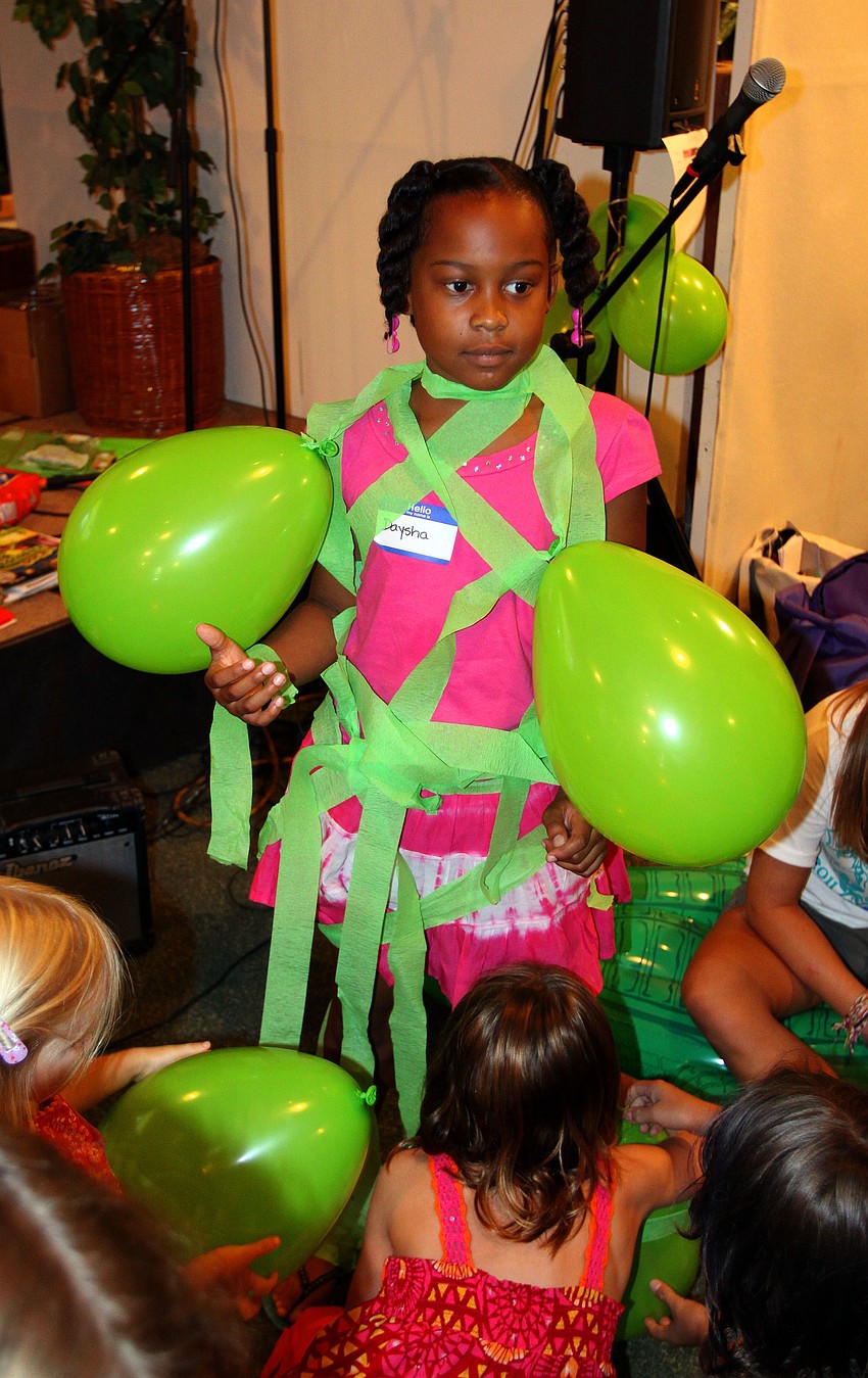 Daysha Brown, 8, gets covered in green crepe paper and balloons during a game Monday, August 8 during vacation bible school at Siesta Key Chapel.