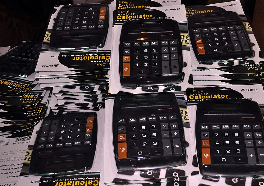 Hundreds of calculators were piled high on the long table full of other school supplies that would be going into all of the backpacks.