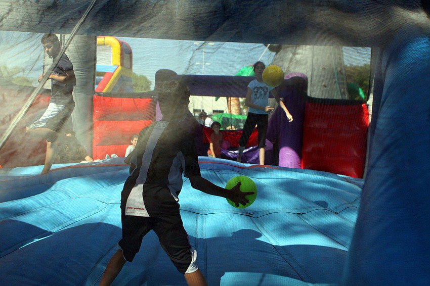 Kids play dodge ball inside a bounce house on Sunday, March 20 at Temple Emanu-El's Purim Carnival.