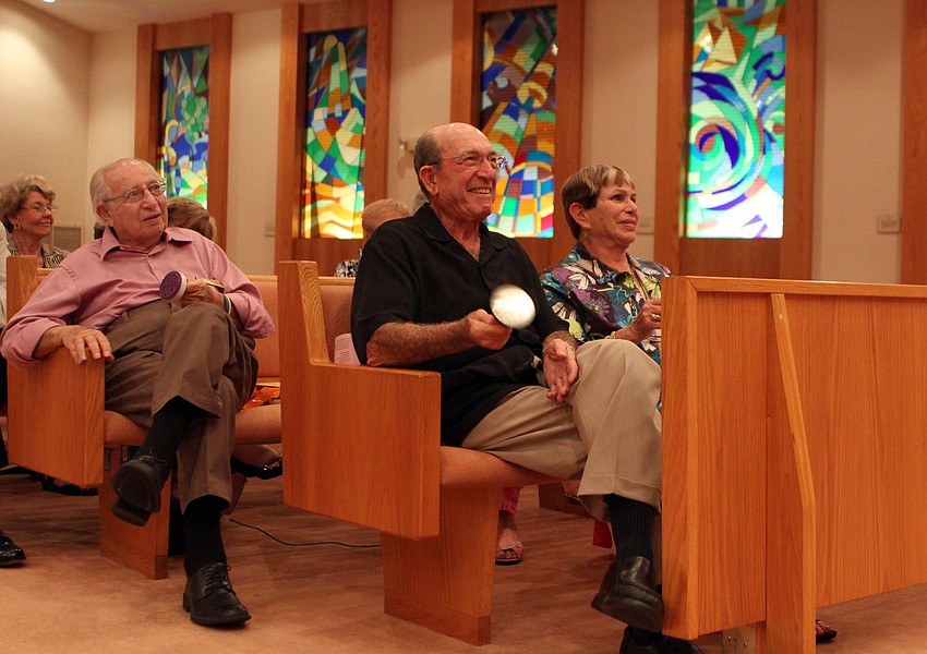 Al Grossman and in the row Dr. David and Louise Solomon shake their groggers, noise makers, when there is any mention of Haman, the bad guy in the Book of Esther, on Saturday, March 19 at Temple Beth Israel.