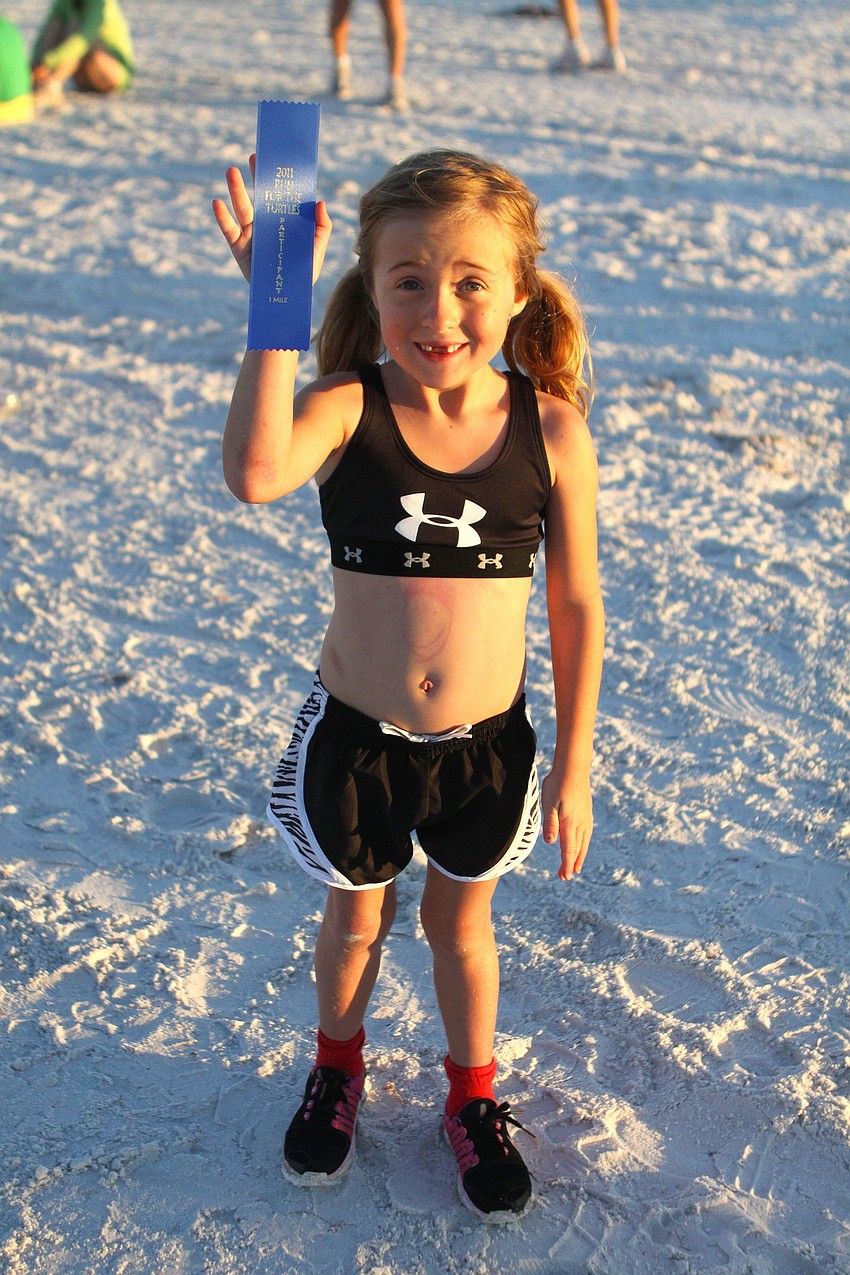 Maura Ryan, 6, shows off her ribbon after taking part in the 1 Mile Fun Run  on Saturday, April 2 as part of the 25th Annual Run for the Turtles on Siesta Key Beach. Ryan completed the mile in 9:26.