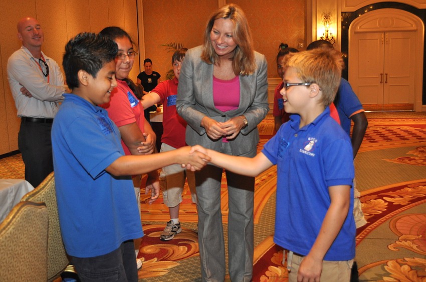 Suzanne Willis teaches Margarito Montoya and Joshua Baker the making of a good handshake.