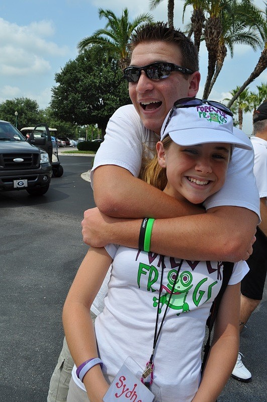 Volunteer Nicholas Green gives a surprise hug to Sydney Wright, 12.