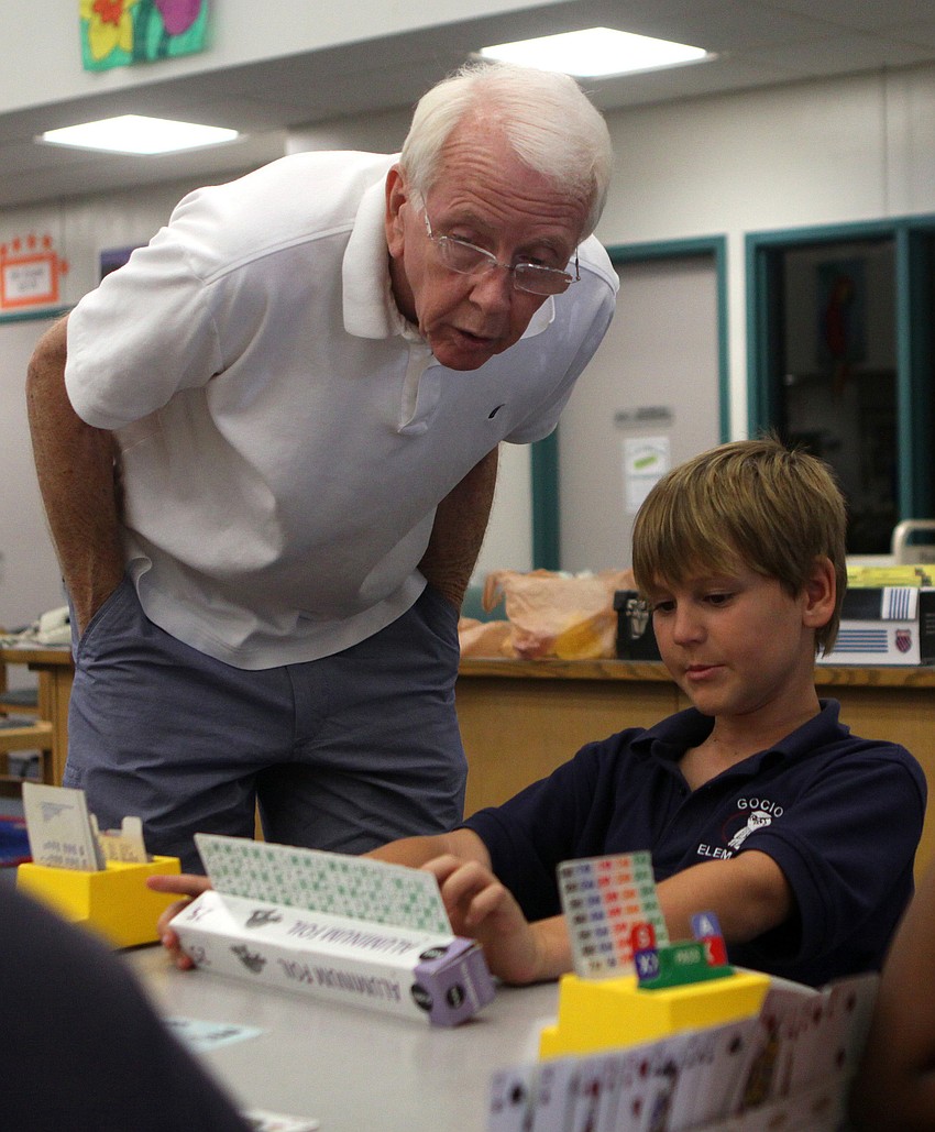 George Kenworthy looks over Atilla Szalay's shoulder while he tries to help Szalay plan his next move during the bridge club's final meeting Monday, May 23 inside Gocico Elementary School's Media Center.