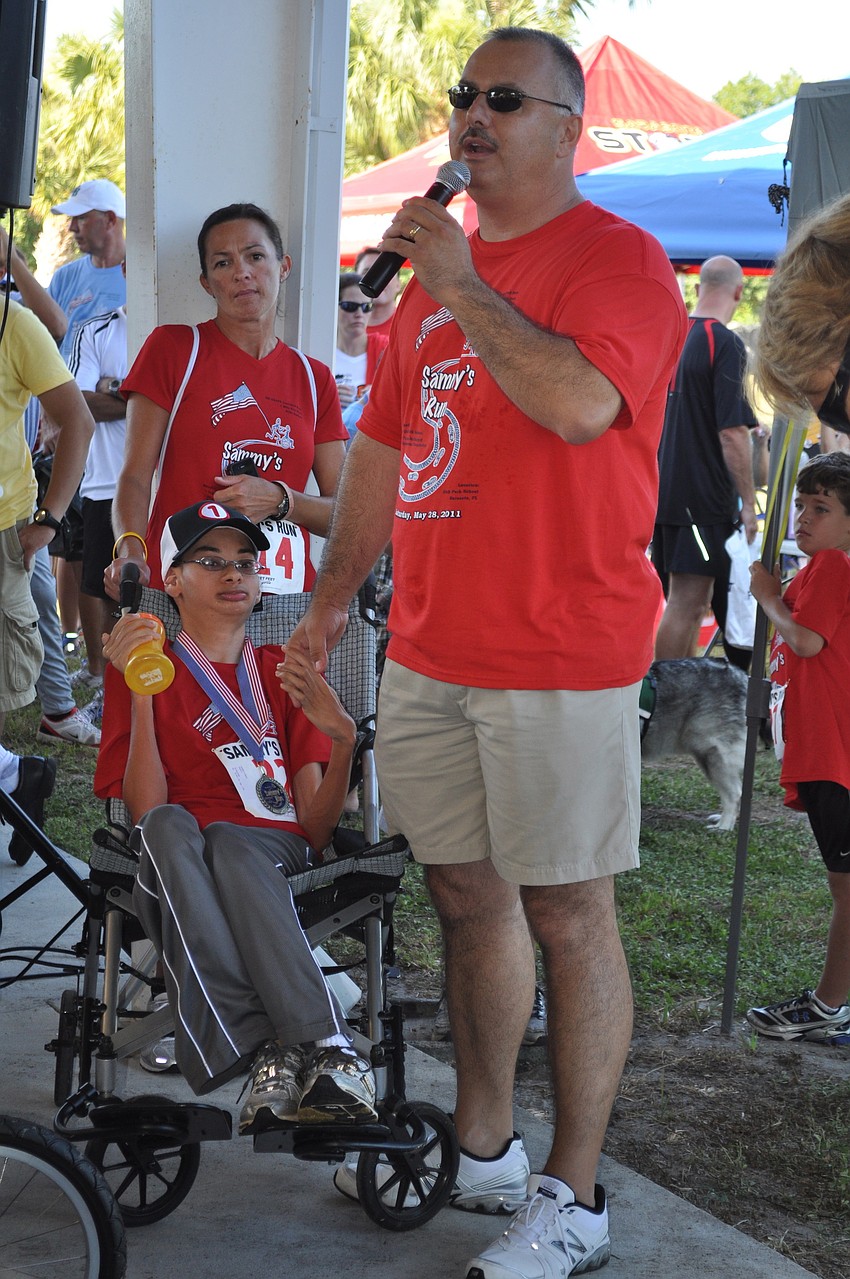 Oak Park School Principal Ron DiPilo gets the crowd clapping for Sammy Lomas, whom the race is named after.