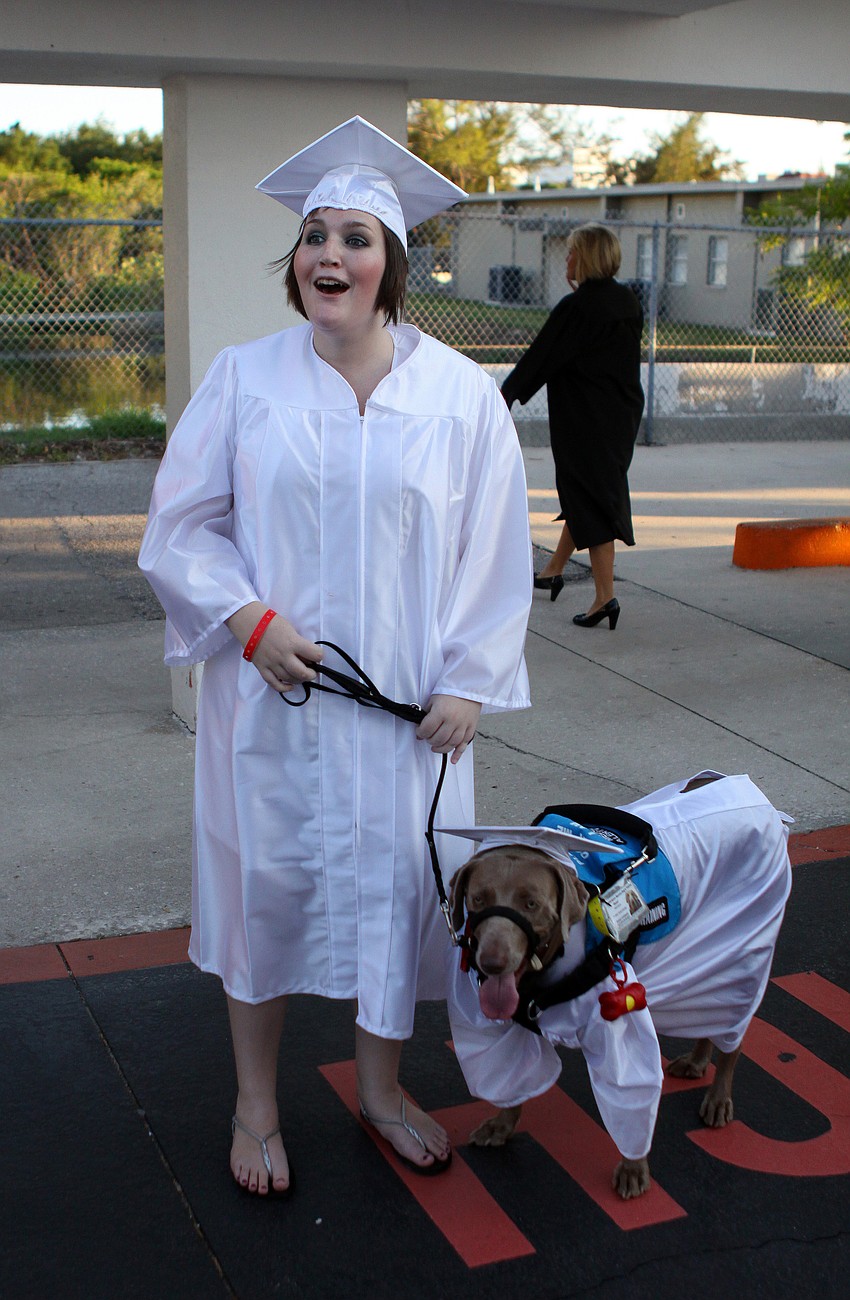 Emily Guttridge and her medical alert dog, Roxie, wore matching caps and gowns Friday, June 3 at Sarasota High School's graduation at Cleland Stadium. Guttridge has a disease known as Ehlersâ€“Danlos syndrome.