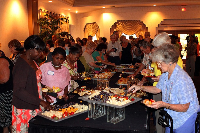 People line up to fill their plates with food.