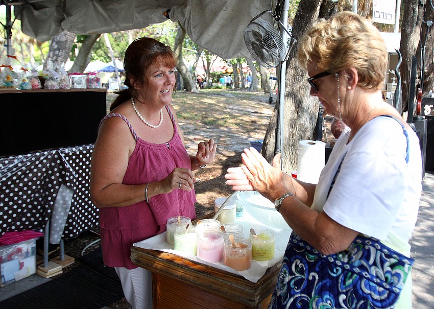 Gwen Mooney tries out one of the soap scrubs made by Pampered Hearts with the help of Janice Champion at the 10th Annual St. Armands Craft Festival Saturday June, 11 at St. Armands Circle.