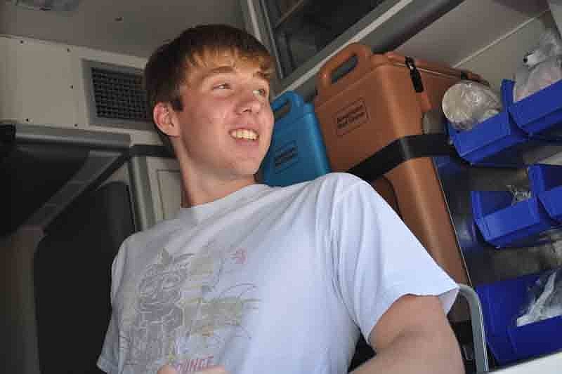 Aaron Kraft, 17, tells fellow campers their lunch is almost ready.