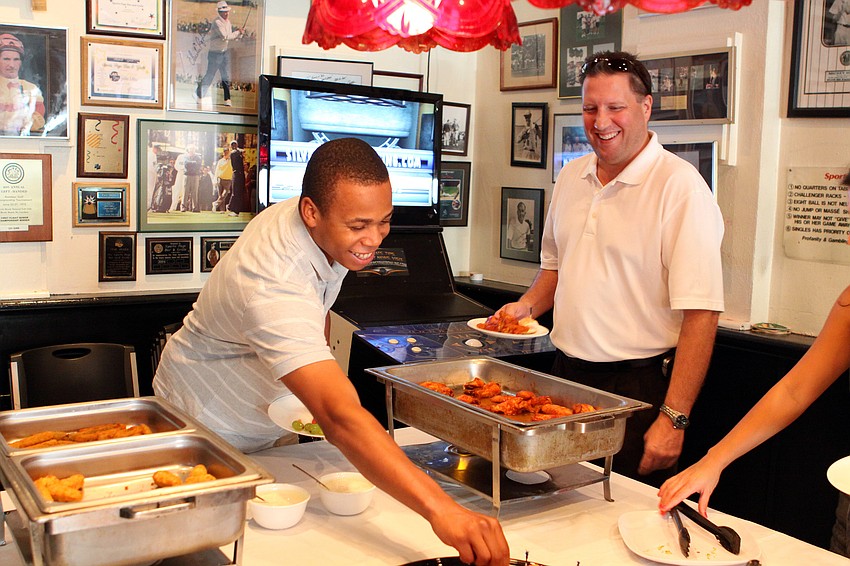 Cedric Granger and Joe Mankowski get some food from the buffet table.