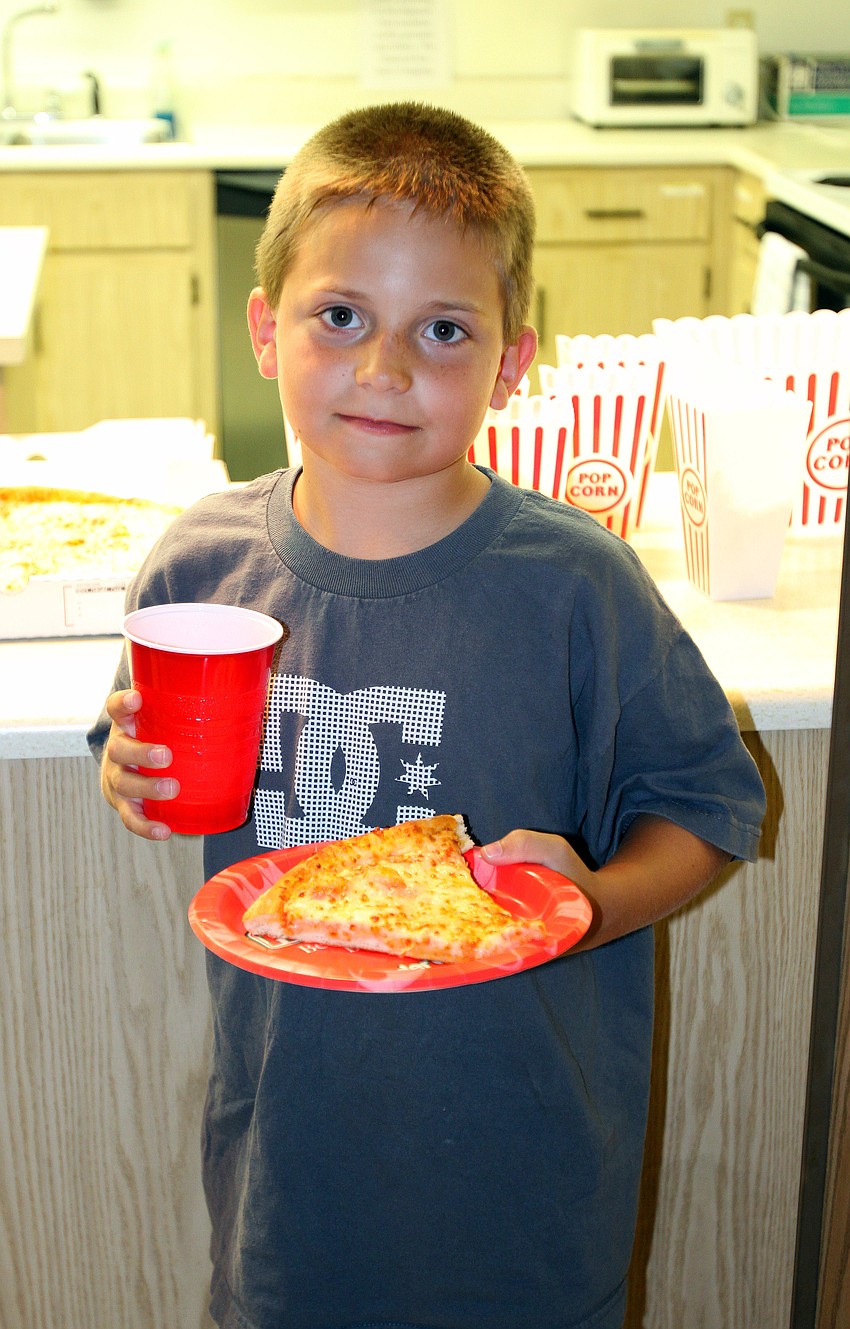 Jay Brunelle, 9, gets ready to chow down on some pizza Friday, Aug. 26 in the Parish Hall.