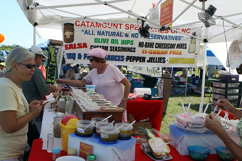 People try out the salsas and dips at the Catamount Specialties of NC booth on Saturday, March 19 at the Sarasota Springfest out at Palmer Ranch.
