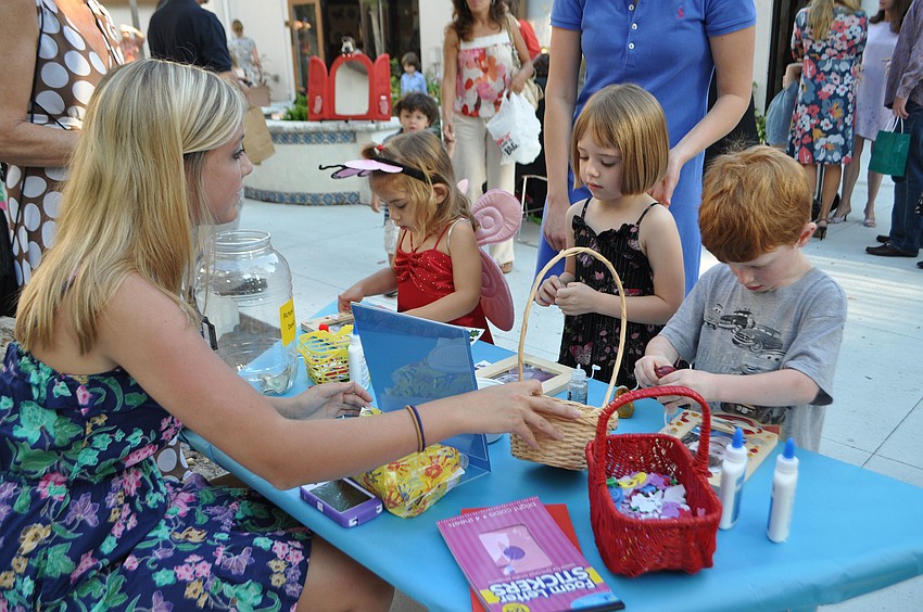 Volunteer Paige Taber helps Chloe Gantert, Reagan Hughes and Trey Banyard with arts and crafts.