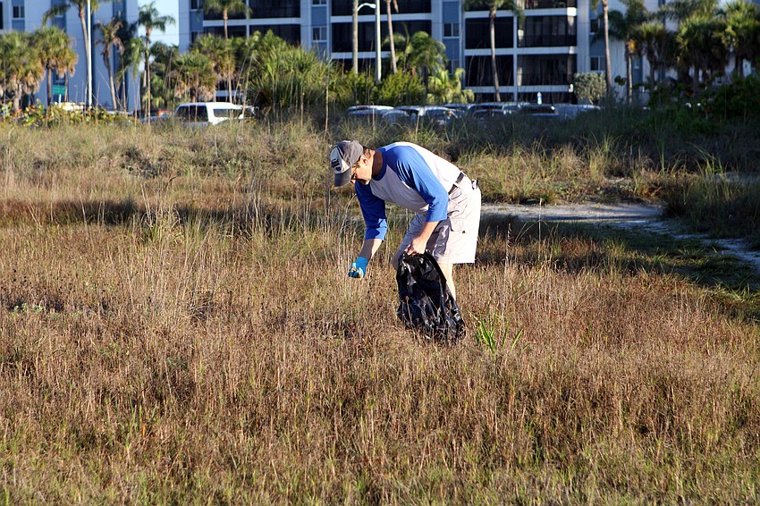 Kevin Smith picks up pieces of plastic and other garbage on Saturday, April 2, on Siesta Key Beach during the 2011 Great American Cleanup, part of Keep Sarasota County Beautiful.
