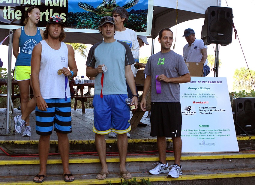 Robert Martini, first place, Peter Roth, second place, and Dave Jensen, 6th place, stand on the steps after getting their awards in the 25-29 mens division on Saturday, April 2 for the 25th Annual Run for the Turtles on Siesta Key Beach.