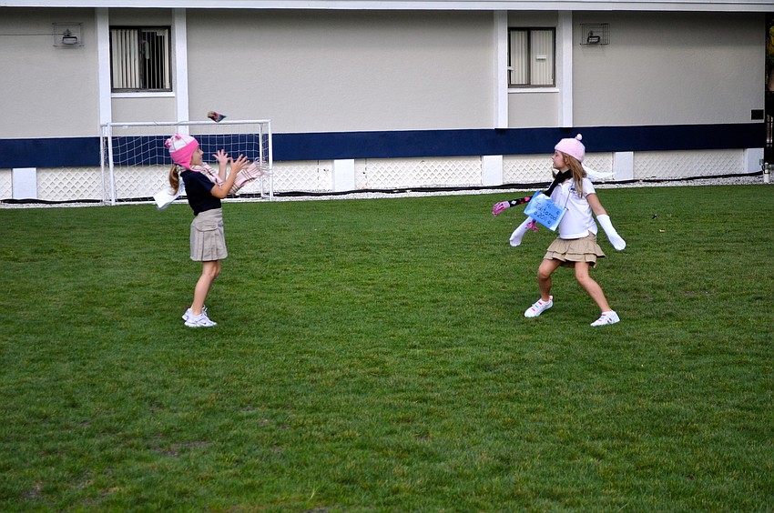 Marissa Govic and Ella Lahners toss bean bags.