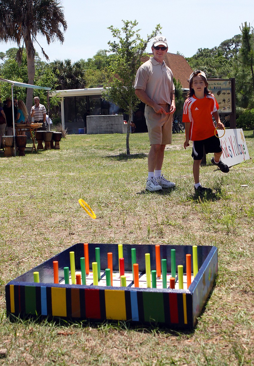 Louis Robinson, 8, throws a ring towards the pegs while his father, Boyd, watches during the Earth Day Celebration on Sunday, April 17 out at Oscar Scherer State Park in Osprey.