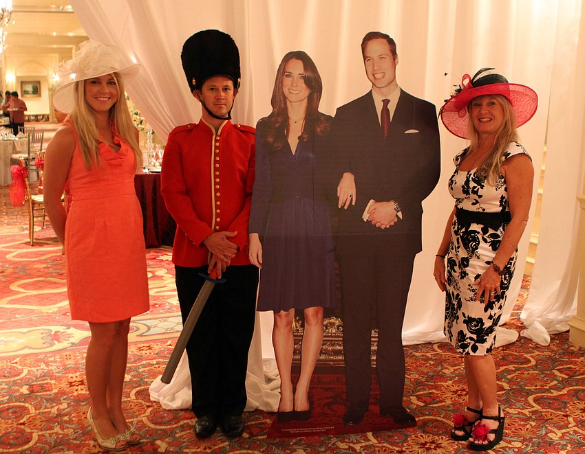 Kristin Hamilton and Jacki Kleppinger pose with a cardboard cut out of Prince William and Kate Middleton along with Chris Starman posing as a guard.