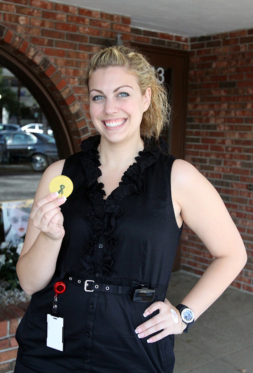 Adrienne Eaton of Achieva Credit Union shows off one of the coins that people collected as part of Pillage the Village fundraising event.