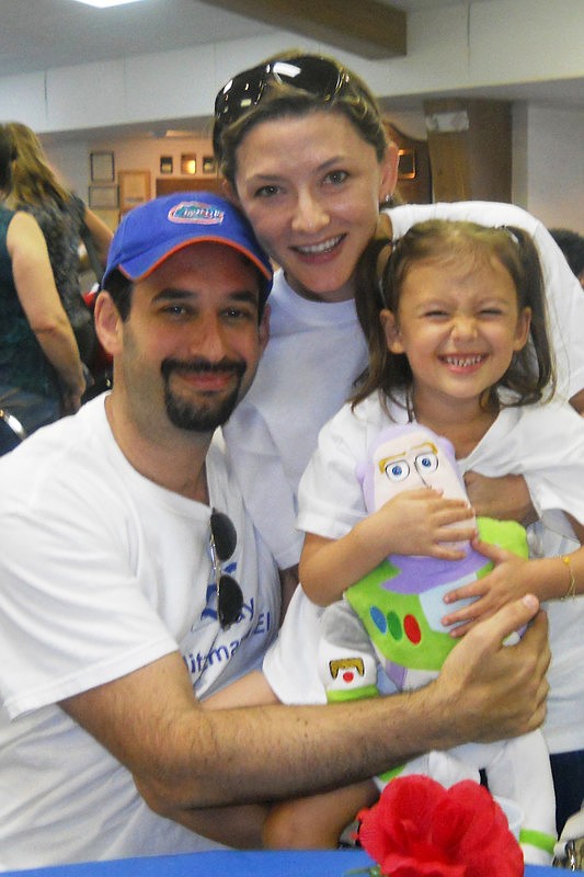 East County family Joey, Kim, and Lily Schlosberg share a hug while making cards for soldiers at Temple Emanu-El Mitzvah Day.