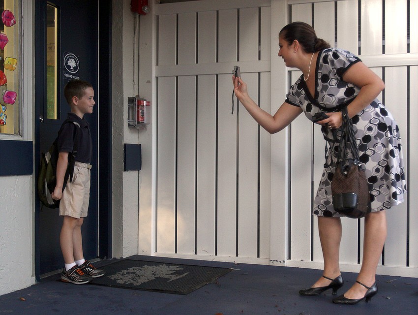Commissioner Christine Robinson takes a photo of her son, E.J. in front of his second grade classroom Wednesday, Aug. 24 at Out-of-Door Academy.
